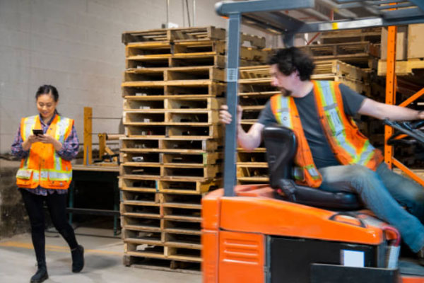 Employee texting while walking, about to be hit by lift-truck.